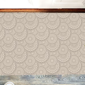 May include: A beige and white patterned doormat with a repeating design of circles with radiating lines. The doormat is made of a soft, durable material and is perfect for adding a touch of style to any entryway.
