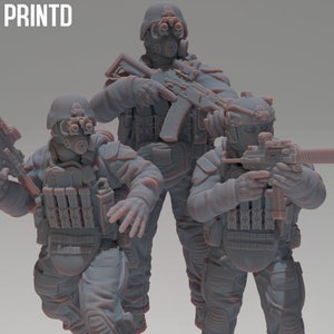 May include: Three grey soldier figurines in tactical gear, including helmets, gas masks, and body armour. Each figure is holding a weapon. The word "PRINTD" is in the upper left corner.