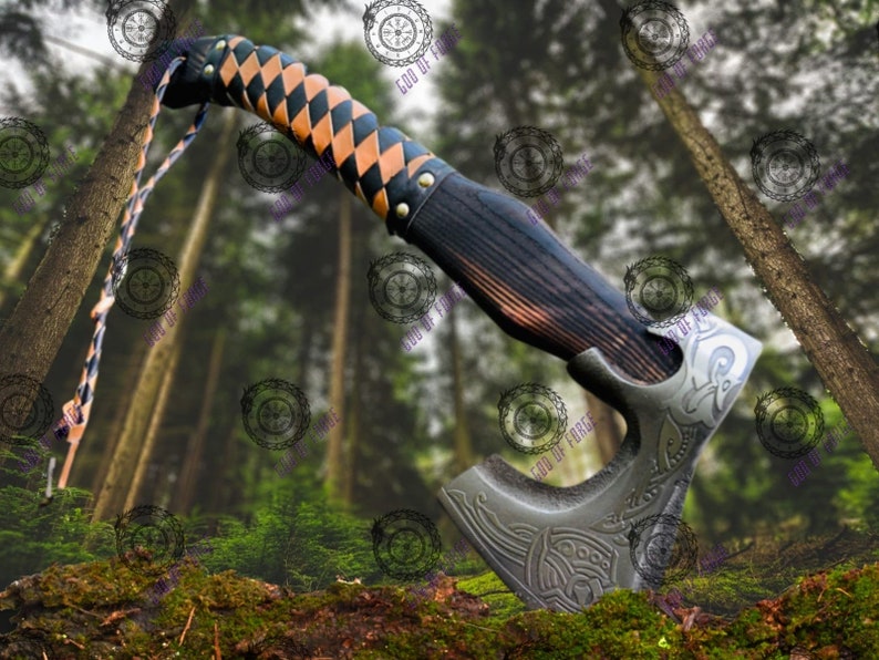 May include: A handcrafted axe with a dark wooden handle and a metal head. The handle is wrapped in a black and tan diamond pattern leather. The axe head features engraved designs. A leather strap is attached to the handle.