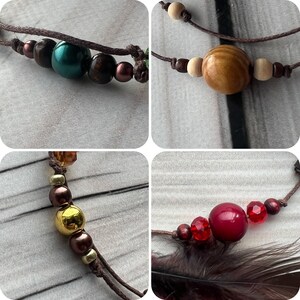 Close-up of handmade feather hair accessories – featuring natural wooden, glass, and metal beads for a unique touch