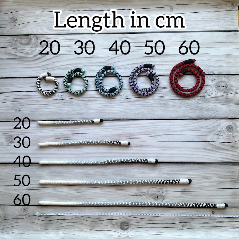 K&ouml;nnte beinhalten: Eine wei&szlig;e Holzoberfl&auml;che mit einem Lineal und f&uuml;nf Schn&uuml;ren in verschiedenen Farben und L&auml;ngen. Die Schn&uuml;re sind mit dem Text "L&auml;nge in cm" und den Zahlen 20, 30, 40, 50 und 60 beschriftet.