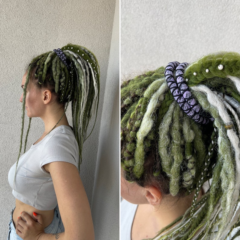 K&ouml;nnte beinhalten: Zwei Frauen mit langen gr&uuml;nen und wei&szlig;en Dreadlocks. Eine Frau tr&auml;gt ein lila-wei&szlig;es Perlenhaarband. Die andere Frau tr&auml;gt ein wei&szlig;es Crop-Top.