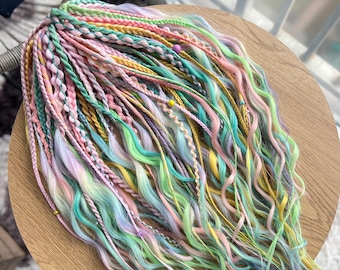 May include: A bundle of colorful synthetic hair extensions in shades of pink, green, yellow, and blue. The hair is braided and has beads woven into the braids.