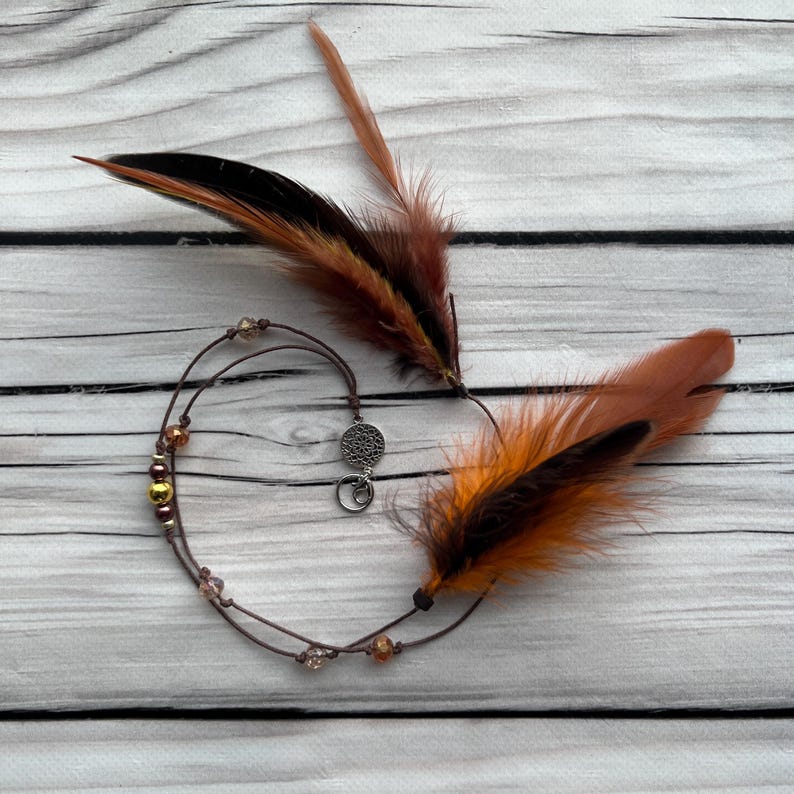 Autumn Flame – warm-toned feather hair accessory with orange and brown hues. A beautiful addition to any festival or nature-inspired look