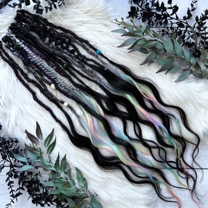 May include: Black and rainbow ombre synthetic dreadlocks with beads. The dreadlocks are wavy and have a subtle iridescent sheen.