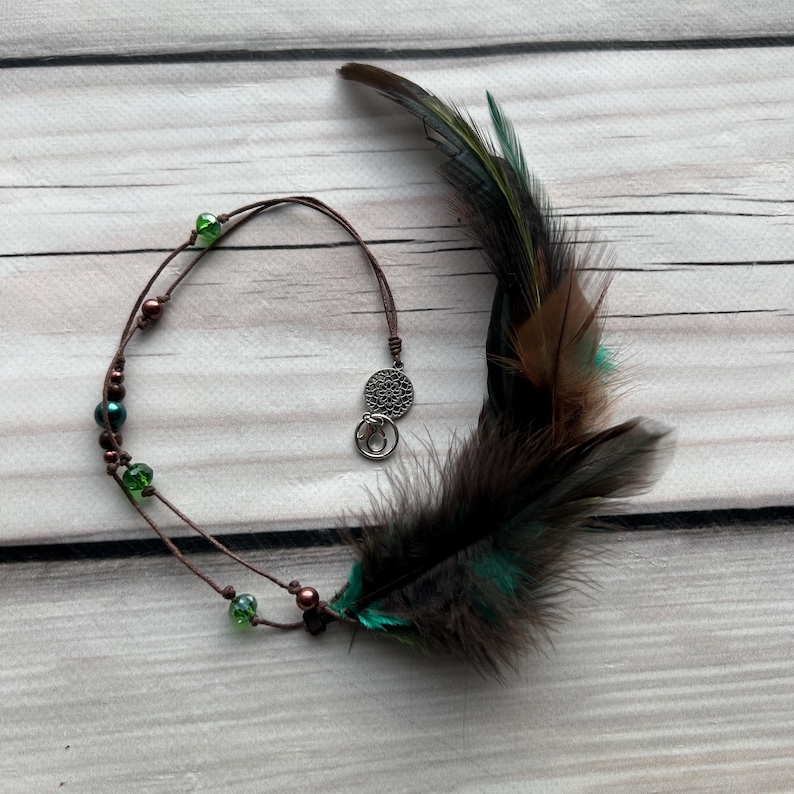 Forest Spirit – earthy green and brown feather hair charm with beads. Inspired by nature, perfect for boho and hippie styles.