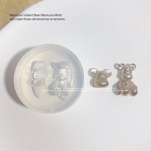 May include: A clear silicone mold for making miniature bear figurines. The mold is shown with two finished resin bear figurines, one standing and one sitting.