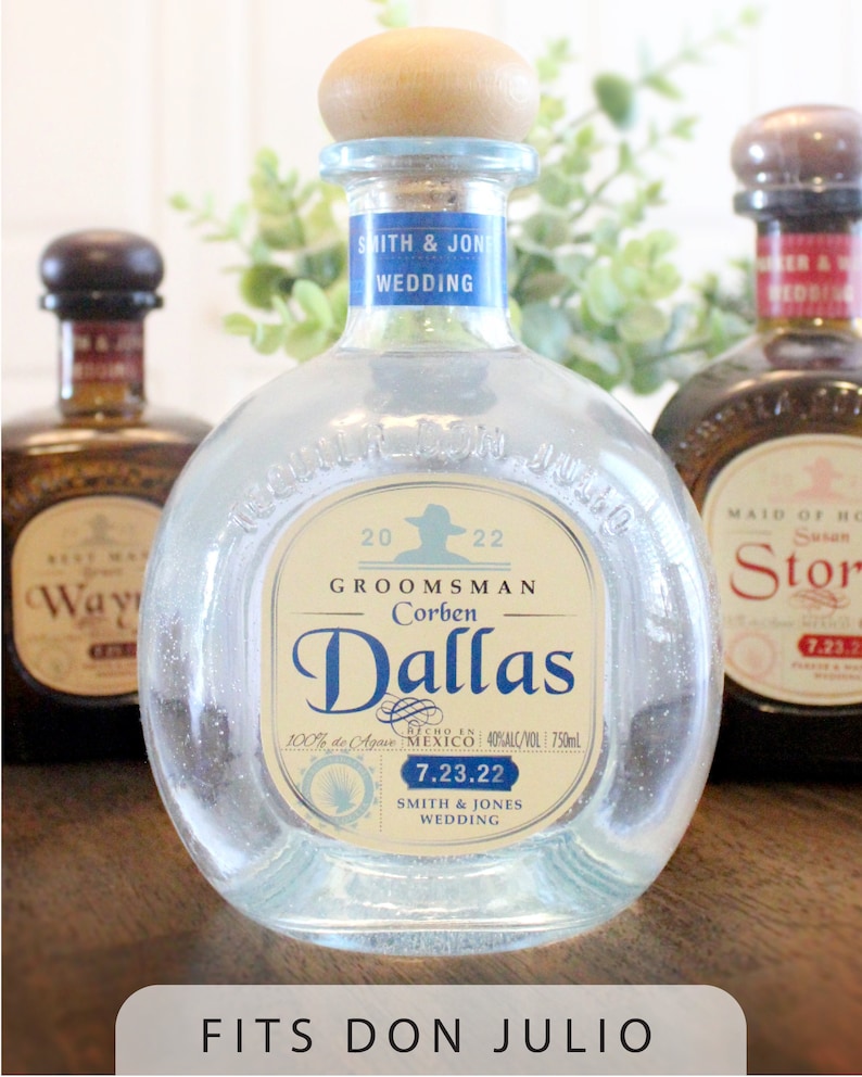 May include: A clear glass bottle of Don Julio tequila with a blue label that says "Groomsmans Corben Dallas" and "Smith & Jones Wedding". The bottle is decorated with glitter and has a cork top.