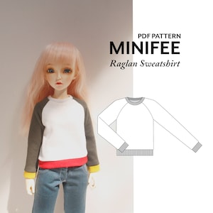 以下が含まれることがあります： MiniFeeドール用のラグランスウェットシャツのPDFパターン。パターンは黒のアウトラインで白い背景に表示されています。人形は白、緑、赤、黄色のカラーリングの同様のスウェットシャツを着ています。