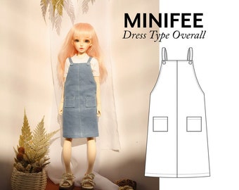 Pode incluir: Um vestido de macacão de ganga azul claro com dois bolsos na frente. O vestido tem alças ajustáveis e é projetado para uma boneca.