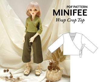 May include: A PDF pattern for a wrap crop top for a doll. The pattern is shown on a white background. The doll is wearing a green and white striped shirt and brown trousers.