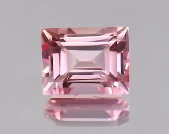 May include: A light pink rectangular cut gemstone with a faceted design.