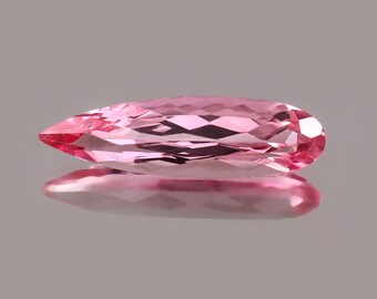 May include: A pink pear-shaped gemstone with facets, reflecting light.