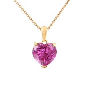 May include: A gold necklace featuring a heart-shaped, pink gemstone pendant. The pendant is a vibrant fuchsia colour and is set in gold-coloured metal. The chain is delicate and also gold-coloured.