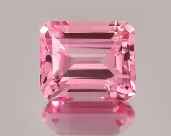 May include: A pink gemstone with a rectangular emerald cut.