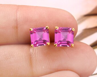 May include: A pair of gold earrings with square pink gemstones.