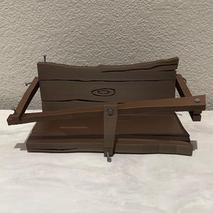 Może przedstawiać: Sekcja drewnianego płotu w kolorze brązowym o postarzanym wyglądzie, z okrągłym sękiem i metalowymi gwoździami. Płot jest uszkodzony i pochylony na bok.