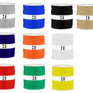 Puede incluir: Doce carretes de cordón en varios colores, incluyendo gris, azul, negro, beige, azul marino, naranja, blanco, rojo, verde y amarillo. Cada carrete tiene una etiqueta blanca con el texto "H1" impreso en ella.