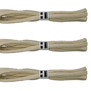 Puede incluir: Tres pares de cordones de zapatos de color crema con una etiqueta "Hummel" en blanco y negro.