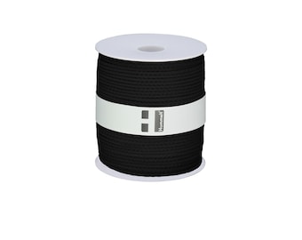 May include: A spool of black cotton cord, wrapped in white paper with the brand name "Hummel" printed on it.