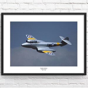 May include: A silver and yellow De Havilland DH-108  jet aircraft in flight. The aircraft has a roundel on the tail and wings, and the text "FMKOO" on the fuselage.