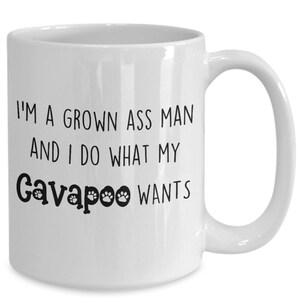 May include: White ceramic coffee mug with black text that reads "I'm a grown ass man and I do what my Cavapoo wants".