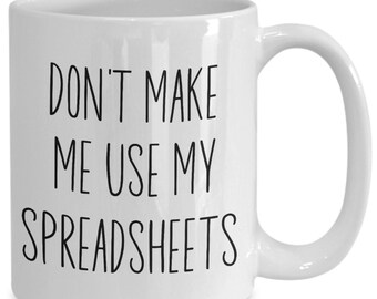 May include: White ceramic coffee mug with black text that reads "Don't make me use my spreadsheets".
