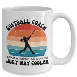 Könnte beinhalten: Weiße Keramik-Kaffeetasse mit einer Retro-Grafik einer Softballspielerin, die einen Ball schlägt. Der Text lautet "Softball Coach Like a Regular Coach Just Way Cooler".