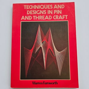 May include: A book titled "Techniques and Designs in Pin and Thread Craft" by Warren Farnworth. The cover is red with gold lettering and a black background featuring a geometric design made of red and white threads.