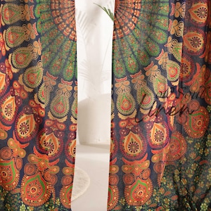 May include: A pair of dark blue curtains with a vibrant mandala design. The pattern features orange, green, and red paisley and floral elements. The curtains are likely made of a lightweight fabric, suitable for home decor.
