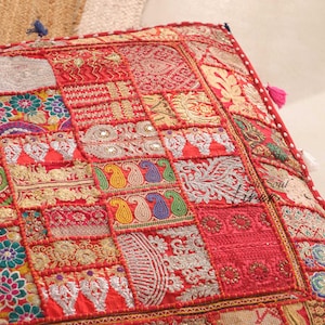 Könnte beinhalten: Ein roter und goldener Patchwork-Kissenbezug mit aufwendigen Stickereien und Perlendetails. Der Kissenbezug besteht aus verschiedenen Stoffen und zeigt eine Vielzahl von Mustern, darunter Paisley, Blumen und geometrische Muster.