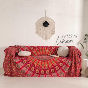 Puede incluir: Mantelería de tapiz mandala roja y dorada con una pared blanca y un tapiz de macramé en el fondo. El texto "old soul linen" es visible en la imagen.
