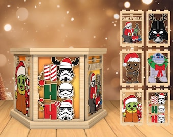 May include: A wooden Christmas lantern with a Santaporian theme. The lantern features a 'Ho Ho Ho' design with Star Wars characters, including Yoda, Chewbacca, and Darth Vader. The lantern is surrounded by smaller wooden ornaments with various Star Wars characters.