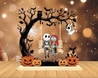 Può includere: Decorazione in legno a tema Halloween con Jack Skellington e Sally di The Nightmare Before Christmas su un'altalena. L'albero nero ha un gufo, pipistrelli e una ragnatela. Lanterne di zucca arancioni sotto.