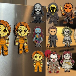 Puede incluir: Una colección de coloridos imanes de dibujos animados con personajes de películas de terror, incluyendo a Chucky, Pennywise y Jack Skellington. Los imanes están adheridos a la puerta plateada de un refrigerador. Cada imán tiene un diseño único.