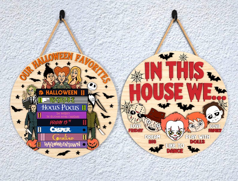 May include: Two round wooden Halloween signs. One says "OUR HALLOWEEN FAVORITES" with images of characters and book titles. The other says "IN THIS HOUSE WE..." with character faces and phrases. Both have rope hangers.