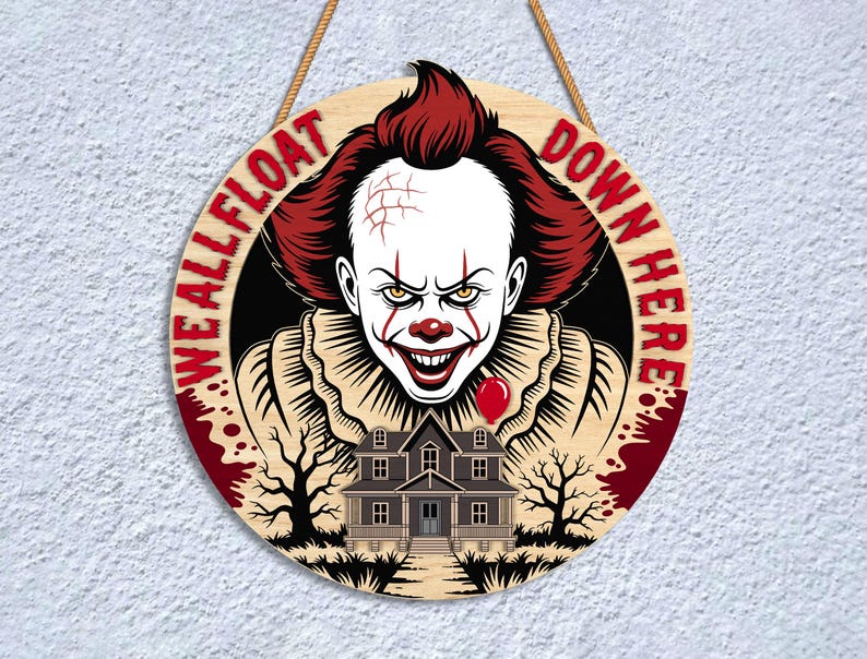 May include: Round wooden sign featuring a menacing clown with red hair and makeup, a red balloon, and a haunted house. The sign reads "WE ALL FLOAT DOWN HERE" in red lettering, perfect for Halloween decor.