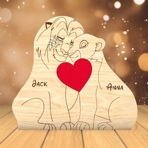 K&ouml;nnte beinhalten: Holzschnitt von zwei L&ouml;wen mit einem roten Herzen dazwischen. Die L&ouml;wen schauen sich an und haben ihre K&ouml;pfe aneinander gelehnt. Die Namen "JACK" und "ANNA" stehen unter den L&ouml;wen.