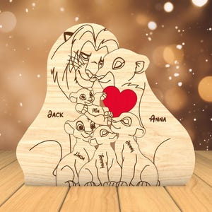 K&ouml;nnte beinhalten: Ein Holzausschnitt einer L&ouml;wenfamilie mit einem Herzen in der Mitte. Der L&ouml;we und die L&ouml;win halten das Herz und die drei Jungen sind darunter. Die Namen Jack, Anna, Mimi, Linda, Tommy und Benny stehen unter jedem L&ouml;wen.