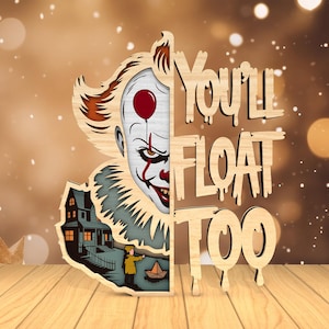 May include: Wooden cutout featuring a menacing clown face with a red balloon, a haunted house, and the phrase "You'll Float Too." The design is layered with natural wood tones and painted details, creating a spooky, decorative piece.