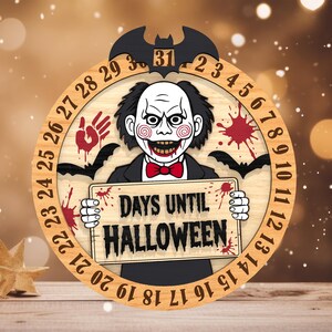 May include: Wooden Halloween countdown clock featuring a spooky character with a red bow tie, holding a sign that reads "DAYS UNTIL HALLOWEEN." The clock has a bat at the top and numbers around the edge, with a handprint and bats.