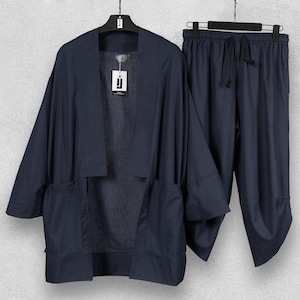 May include: A navy blue linen kimono jacket and matching drawstring trousers set. The jacket features large front pockets and a relaxed fit. The trousers have a loose, comfortable design. The set is displayed on a hanger.