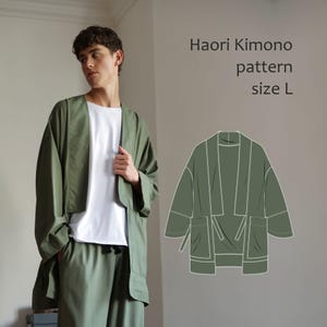 Può includere: Una giacca kimono Haori verde oliva, taglia L, indossata sopra una maglietta bianca e pantaloni abbinati. L'immagine include anche un disegno al tratto del kimono. Il testo sull'immagine recita "Haori Kimono pattern size L."