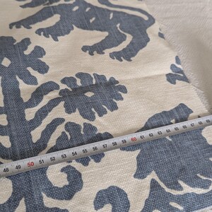 May include: Close-up of a white fabric with a blue floral pattern. A measuring tape is placed on the fabric, showing a measurement of 50 inches.