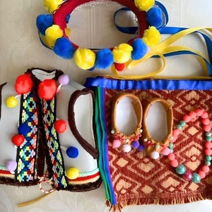 May include: A set of traditional Ukrainian folk costume accessories, including a headband with yellow and blue pom-poms, a white vest with colorful embroidery, a pair of brown leather slippers with pom-poms, and a red and brown bag with a colorful patterned fabric.
