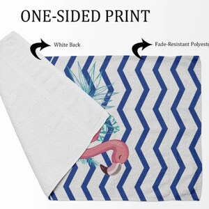 May include: One-sided beach towel with a white back and a blue and white chevron pattern on the front. The front also features a pink flamingo with tropical leaves.