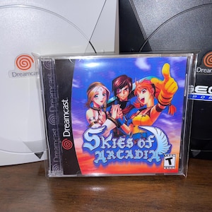 Op de afbeelding: Een gamecase voor Skies of Arcadia, met drie personages in anime-stijl. De case zit in een plastic hoes, met het Dreamcast-logo zichtbaar. De game is beoordeeld met T voor tieners.