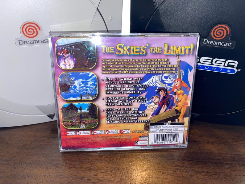 May include: Dreamcast game case for "The Skies of the Limit!" featuring colorful artwork of characters and scenes from the game. The case has text describing gameplay features and is set against a white and black Dreamcast console.