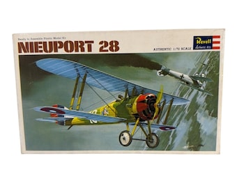 May include: A Revell 1/72 scale plastic model kit box for a Nieuport 28 biplane. The box art features a yellow and green biplane with a red engine cowling in flight, alongside a second aircraft, against a dark, cloudy sky background.