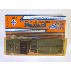 May include: A Roco Minitanks HO scale model of an Armoured Command Post M 577 A1 in olive green plastic, enclosed in its original orange and blue cardboard packaging with the text 348 S, HO Model Miniatures, and Minitanks printed on the front.